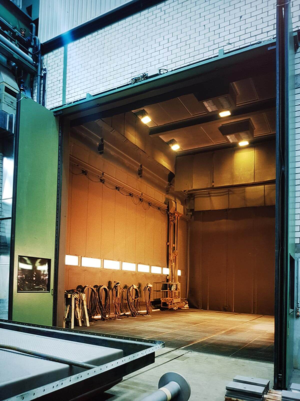 Grosses Strahlhaus mit offenem Tor und Strahlwagen für grosse Werkstücke